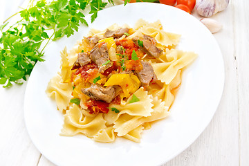 Image showing Farfalle with turkey and vegetables in sauce on light board