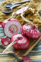 Image showing Sweet red onions on an old wooden board.