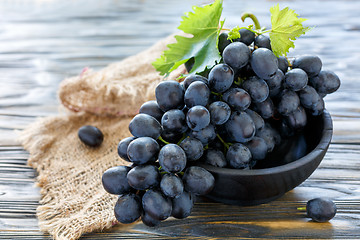 Image showing Delicious black grapes in a wooden bowl.