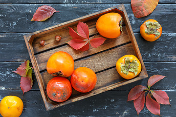 Image showing Juicy ripe persimmon in a wooden box.