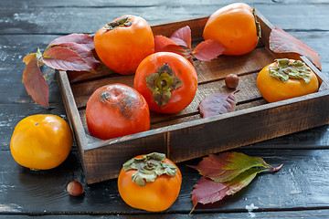 Image showing Juicy ripe persimmon in a wooden box.