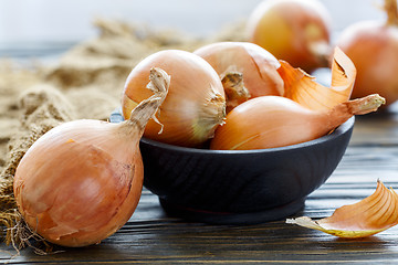 Image showing Yellow onion in a wooden bowl.