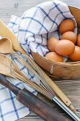 Image showing Brown eggs in old sieve,rolling pin,whisk and spoon.