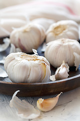 Image showing Garlic, cloves and peel on a wooden dish.
