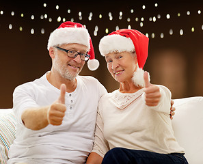 Image showing happy senior couple in santa hats for christmas