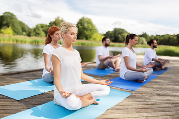 Image showing people meditating in yoga lotus pose outdoors