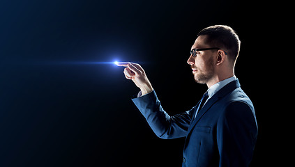 Image showing businessman in glasses with laser light over black