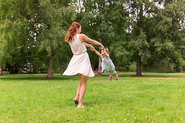 Image showing happy mother playing with baby girl at summer park