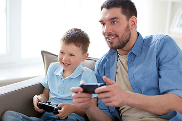 Image showing father and son playing video game at home