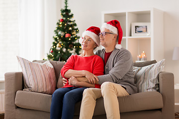 Image showing happy senior couple in santa hats at christmas