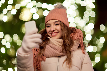 Image showing happy woman with smartphone at christmas