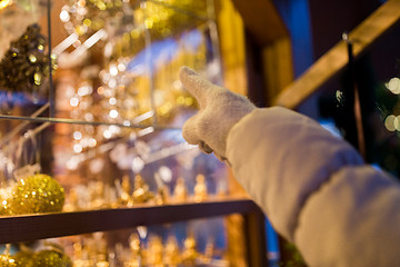 Image showing hand pointing at christmas toys behind shop window