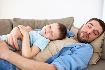 Image showing happy father and son sleeping on sofa at home