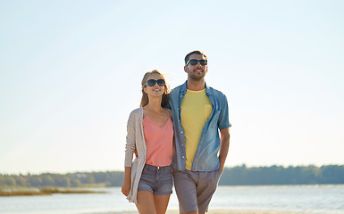 Image showing happy couple in sunglasses hugging on summer beach