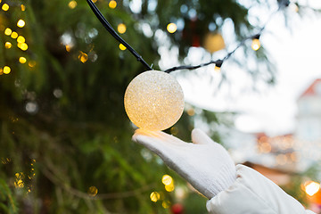 Image showing close up of hand with christmas tree garland bulb