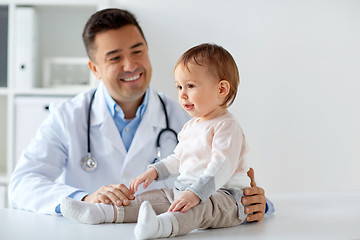 Image showing happy doctor or pediatrician with baby at clinic