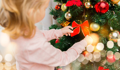 Image showing close up of little girl decorating christmas tree