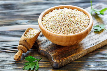 Image showing Pearl barley in a wooden bowl and scoop with barley.