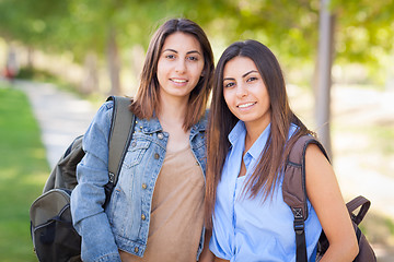 Image showing Two Beautiful Young Ethnic Twin Sisters With Backpacks Walking O