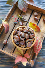 Image showing Bowl with ripe chestnuts on a wooden box.