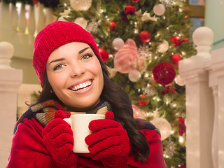 Image showing Warmly Dressed Female With Mug In Front of Decorated Christmas T