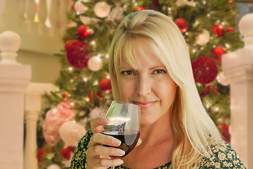 Image showing Blond Woman with Wine Glass In Front of Decrated Christmas Tree.