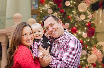 Image showing Happy Young Parents with Baby In Front of Decorated Christmas Tr