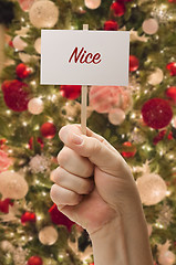 Image showing Hand Holding Nice Card In Front of Decorated Christmas Tree.