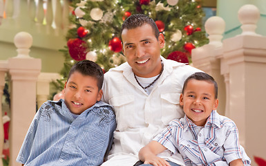 Image showing Hispanic Young Father and Sons In Front of Decorated Christmas T