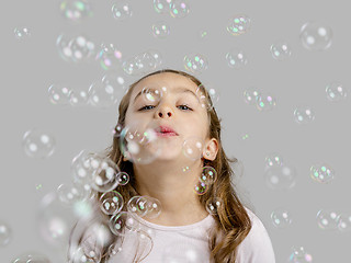 Image showing Girl playing with soap bubbles