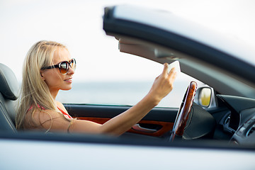 Image showing woman in convertible car taking selfie