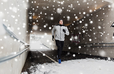 Image showing man running along subway tunnel in winter