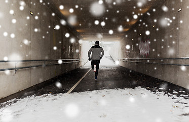 Image showing man running along subway tunnel in winter