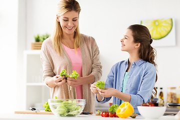 Image showing happy family cooking salad at home kitchen