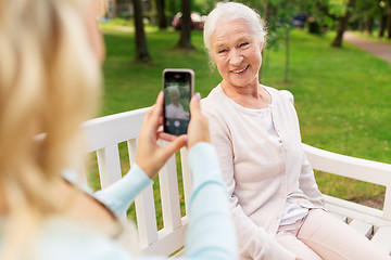 Image showing daughter photographing senior mother by smartphone