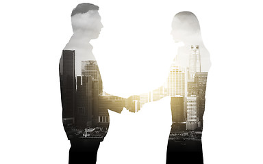 Image showing business people shaking hands over city background