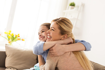 Image showing happy smiling family hugging on sofa at home