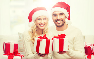 Image showing happy couple at home with christmas gift boxes