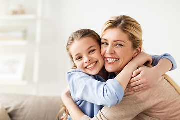 Image showing happy smiling family hugging on sofa at home