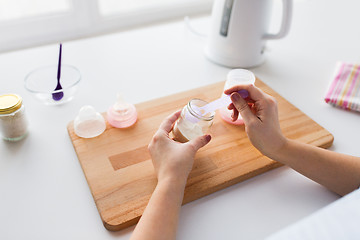 Image showing hands with infant formula making baby milk