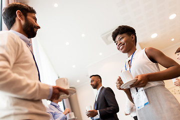 Image showing business people with conference badges and coffee