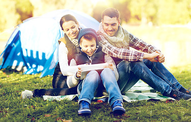 Image showing happy family with tablet pc and tent at camp site