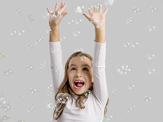 Image showing Girl playing with soap bubbles