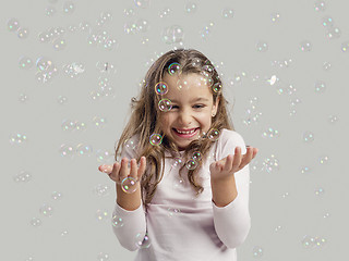 Image showing Girl playing with soap bubbles