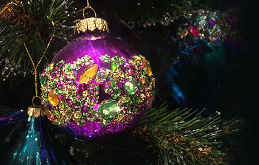 Image showing Encrusted with crystals Christmas tree decorations hang on a tre