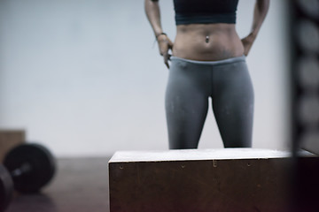 Image showing black woman is performing box jumps at gym