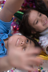 Image showing kids  blowing confetti while lying on the floor