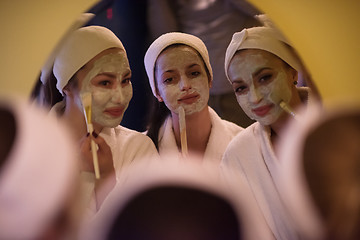 Image showing women putting face masks in the bathroom