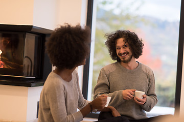 Image showing multiethnic couple  in front of fireplace