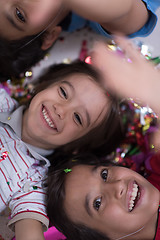 Image showing kids  blowing confetti while lying on the floor